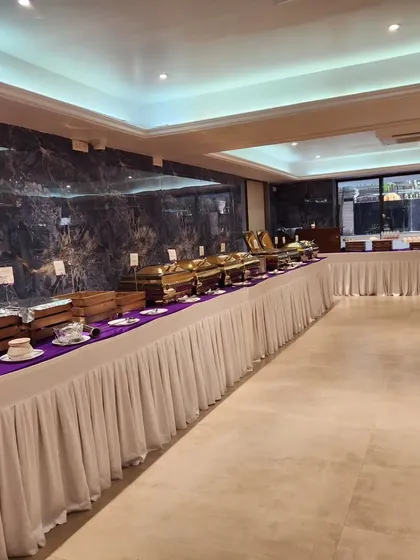 An angled shot of a long buffet line, showcasing the clean and organized arrangement. This setup is perfect for formal banquets and wedding receptions.