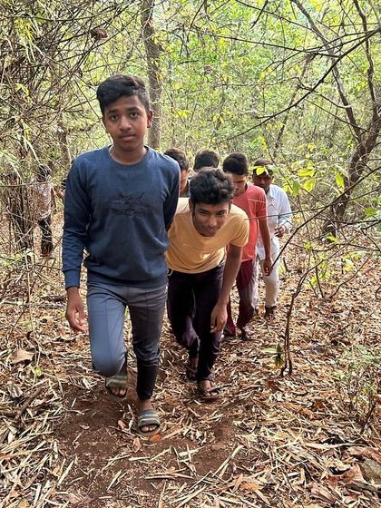 A line of young trekkers makes its way through the woods, learning about endurance and navigation.