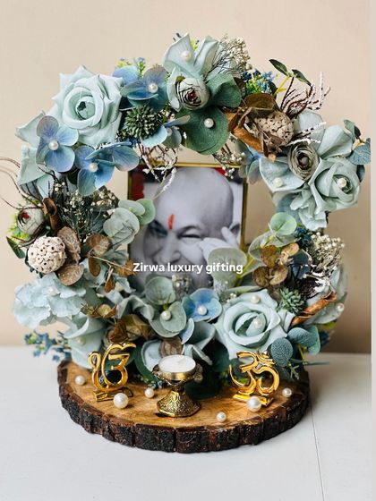 A unique Guruji Darbar designed with cool shades of blue and green florals. Set on a wooden slice, it features two golden Om symbols, creating a balanced and peaceful composition.