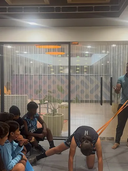 Teaching a group of young athletes about mobility. Here, I'm demonstrating a hip mobility drill to help them understand the importance of a proper warm-up.
