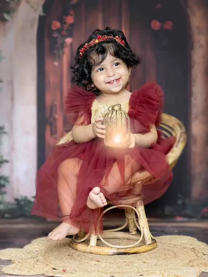 Her first adventure begins. Holding a glowing lantern, this little one looks like she's stepped right out of a fairytale for her first birthday pictures.