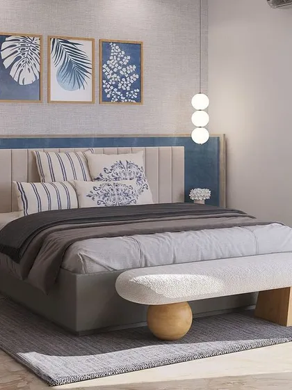 Where modern lines meet soft textures. This bedroom design for a DLF Phase 2 project invites calm with a layered palette, a wide upholstered headboard, and sculptural accents like the unique bench and pendant lights.