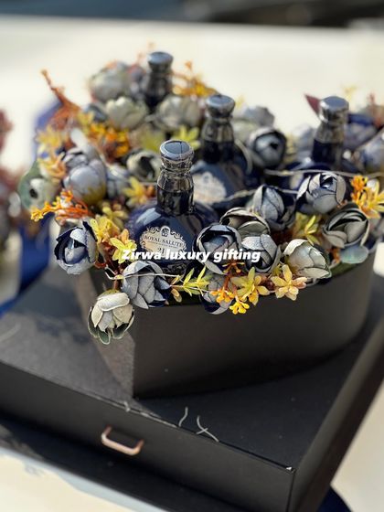 A bold and luxurious choice for him. This heart-shaped box is filled with Royal Salute whiskey miniatures nestled among blue and yellow flowers.