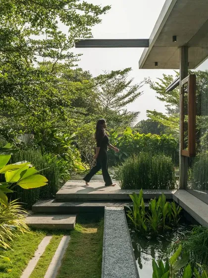 The reflection in the glass facade merges the built form with the lush garden. This seamless connection between indoors and outdoors is a core principle of our architectural philosophy, creating a tranquil oasis for the residents.