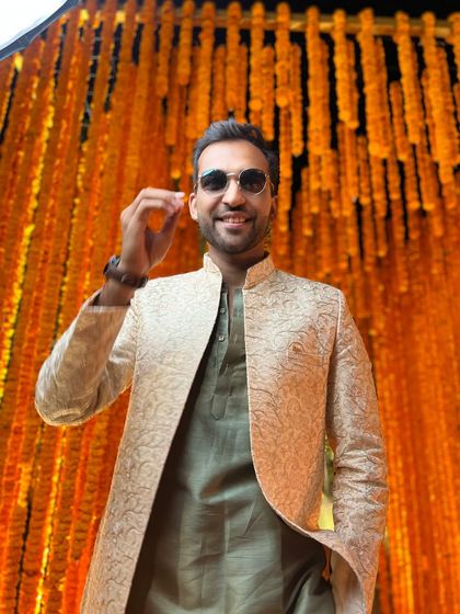 My swag is always on top. Posing against a marigold backdrop, this look is perfect for a Haldi or Mehendi ceremony.