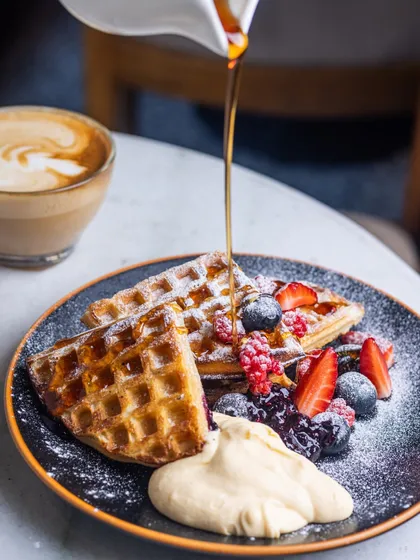 I love watching the syrup cascade over a stack of warm waffles. Mine are made to be crisp on the outside with a soft, airy heart, topped with a medley of fresh berries and a dollop of whipped cream. It’s pure, simple joy on a plate.