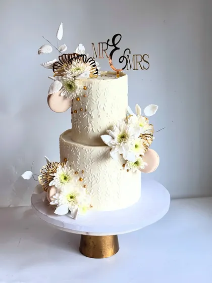 The details on this wedding cake, from the stenciled texture to the delicate placement of flowers, are what make it a true work of art.