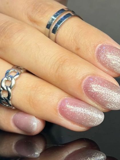 A delicate and shimmery cat-eye effect in a soft pink hue, perfect for an elegant and feminine manicure.