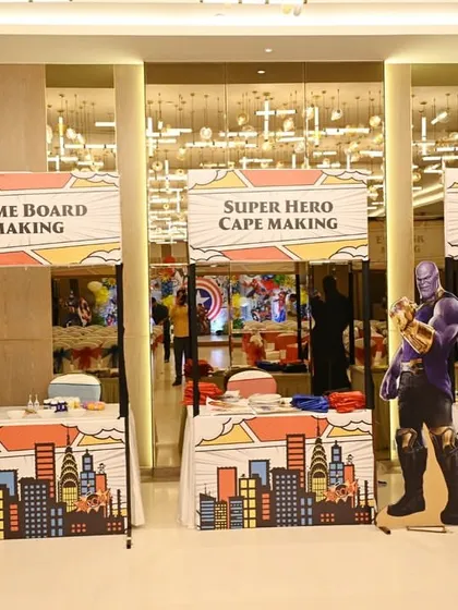 Interactive stations are key to an engaging event. For this superhero-themed party, we had name board, cape, and eye mask making stations. These kinds of activities are perfect for corporate family days or team-building events to get everyone involved.