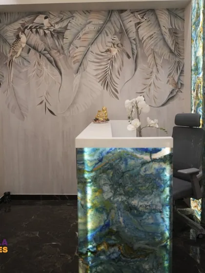 The reception desk itself is a piece of custom furniture, featuring a backlit stone front that matches the main entrance frame. This detail ensures a consistent and high-end design language throughout the space.