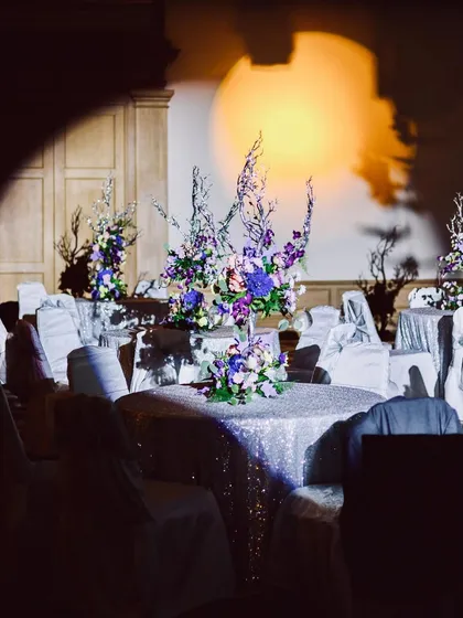 The sangeet ambiance under a spotlight. The combination of sequined tablecloths, unique floral centerpieces, and dramatic lighting created a space that felt both glamorous and intimate.