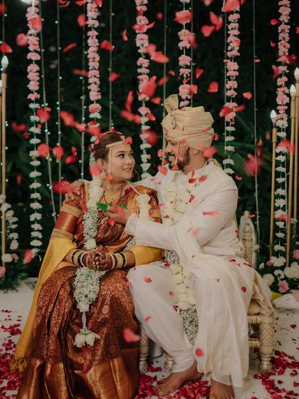 A romantic moment under a shower of rose petals. The beautiful decor and the couple's loving gaze create a truly cinematic wedding photograph.