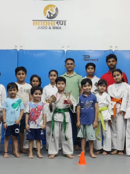 Our young warriors from the kids' karate and judo program celebrating a gold medal win. We focus on building discipline, confidence, and respect in children from a young age, giving them skills that last a lifetime.