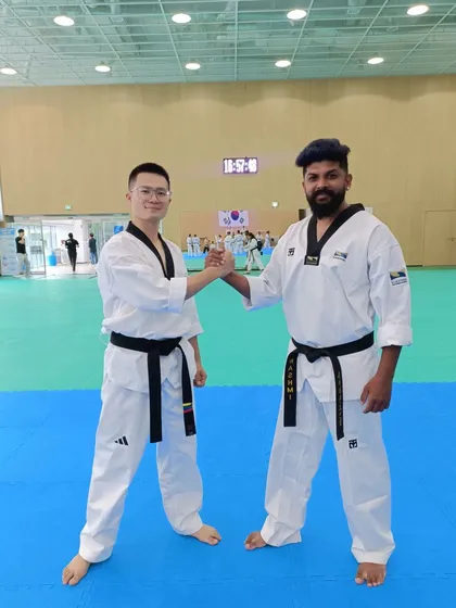 A handshake of sportsmanship with a fellow black belt at the international training program.