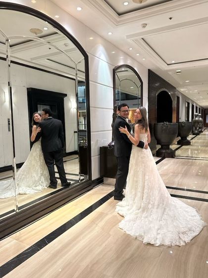 A romantic shot in a grand hotel lobby, showcasing the beautiful train of our white lace wedding gown.
