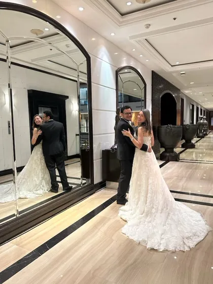 Making your fairytale moments a reality. This couple looks picture-perfect in a classic black suit and a beautiful white lace wedding gown with a full train.