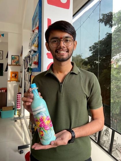 A participant with his finished decoupage bottle. The workshop is open to everyone, and no prior experience is needed.