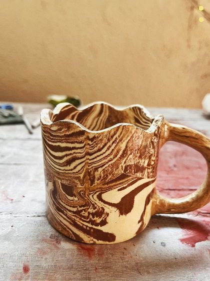Look at these beautiful little wares from a beginner's course. She created a lovely marbled mug, a textured vase, and a carved luminary with a rich, rustic glaze.