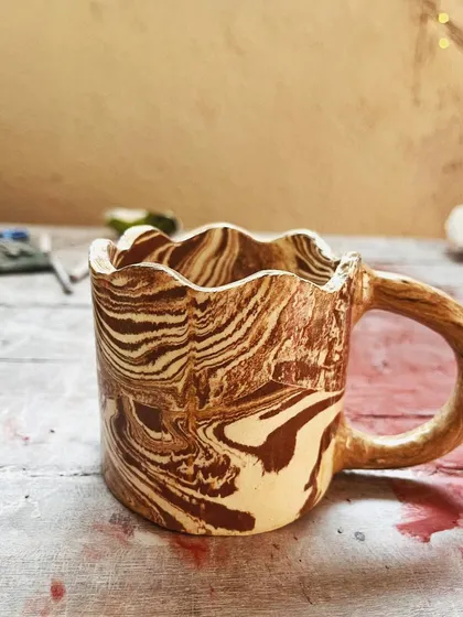 Look at these beautiful little wares from a beginner's course. She created a lovely marbled mug, a textured vase, and a carved luminary with a rich, rustic glaze.