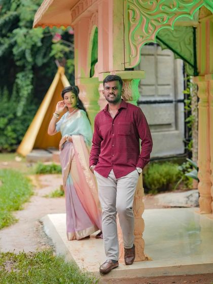 A candid-style shot of a couple walking through our garden, with a colorful gazebo in the background.
