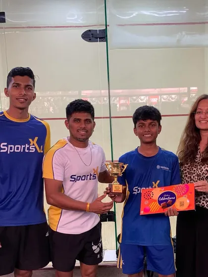 The winner of the Squash Star Academy tournament, Maruti Dodayanoor, receives his trophy.