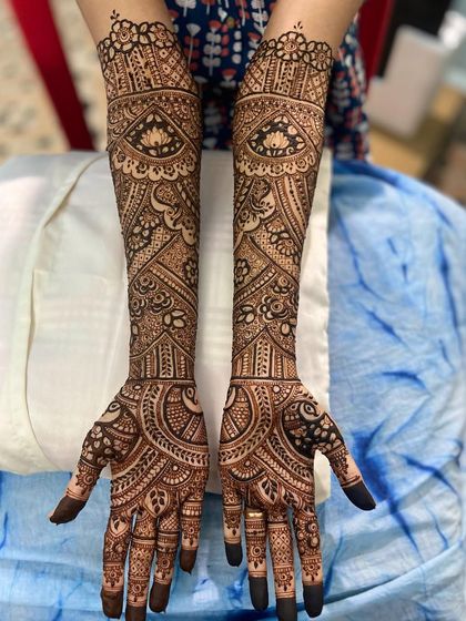 A full-arm design with a mix of bold Arabic-style flowers and dense Indian filler patterns, creating a stunning fusion look.