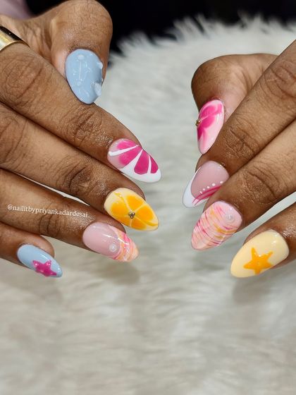 A close-up of the final tropical-themed nail set, showcasing the bright, fun colors and cute, hand-painted details like citrus slices and starfish.