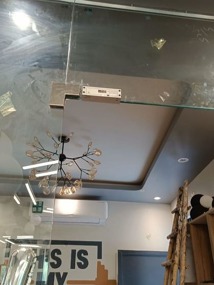 This image shows the EM lock and bracket assembly on the top corner of the gym's glass door, providing a strong and secure locking point.