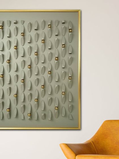 This modern art shadow box features pastel-colored leather work with gold metal ornaments. The repeating oval shapes create a rhythmic and minimalist design that is both subtle and sophisticated.
