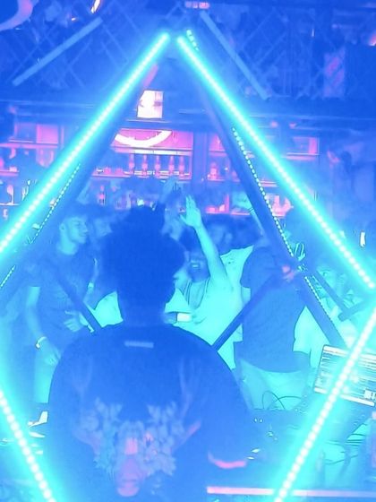 A cool shot of me from behind, framed by the blue neon pyramid at The Fixx Bar.