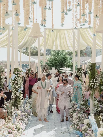 A wide shot of the groom's procession, showing the scale of the floral decor and the beautiful canopy ceiling that framed the entire ceremony space.