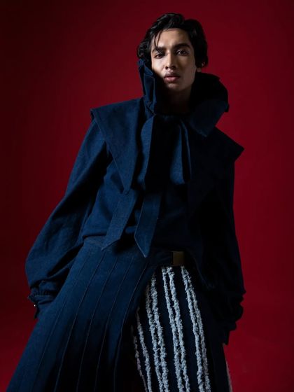 A close-up of the dramatic, high-collar look, focusing on the model's intense expression.