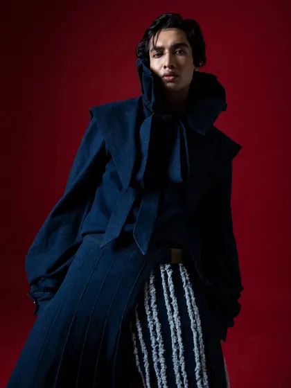 Focusing on the dramatic collar and the model's intense expression. This is where fashion photography becomes character study.