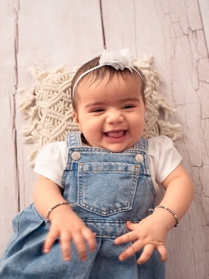 The happiest smile from this six-month-old beauty. A simple, clean backdrop allows her joyful expression to be the star of the photo.