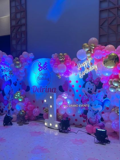 Another angle of the main stage, highlighting the 'Happy Birthday' neon sign and the mix of metallic gold and pink balloons.