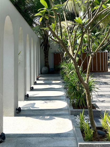 The play of light and shadow is a key design element. Here, the sun casts the shape of the arches onto the walkway, creating a dynamic, artistic pattern on the floor that changes throughout the day.