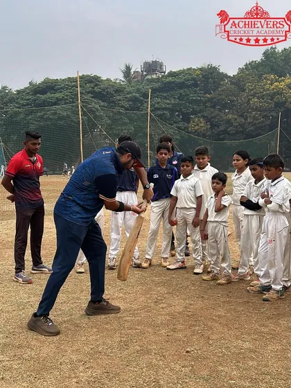 Another angle of our coach providing a hands-on batting demonstration. We emphasize learning by seeing and doing.