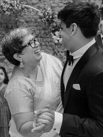 A mother and son share a dance, their faces lit up with happiness. Capturing these genuine interactions between family members is a core part of my documentary wedding photography philosophy.