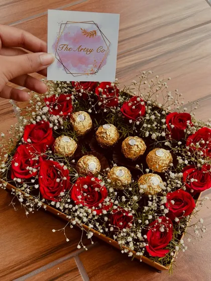 Showcasing our branding, this image features our elegant box of red roses and Ferrero Rocher, complete with The Artsy Co. card. It's a mark of quality and thoughtful design.