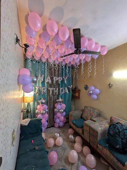 A high-angle shot showing the canopy of balloons covering the ceiling for a birthday surprise.