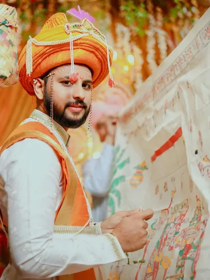 The groom holds the sacred antarpat, a key moment in a Maharashtrian wedding. He looks towards his bride, his expression full of anticipation for the moment the cloth will be lowered.