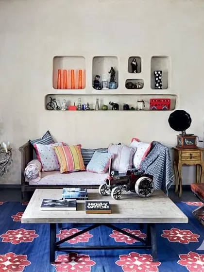 This living room, designed for Kangana Ranaut, is a beautiful chaos of collected items. A gallery wall, a vintage gramophone, and a bold blue rug come together to create a space that is deeply personal and full of character, reflecting her unique spirit.