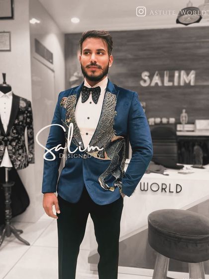 A client wearing a royal blue suede velvet tuxedo with an embroidered flying horse. The texture of the velvet combined with the metallic thread creates a rich, luxurious look.