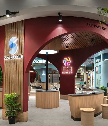 The central pavilion for E3 and Skydecor acts as a striking anchor point within the 500 sq.m space. Its curvilinear design, finished in deep red and wood tones, creates a dynamic hub for interaction and branding.