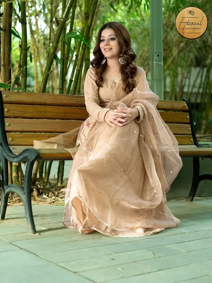 A full-length portrait of a model in a graceful ethnic outfit, set against a natural bamboo background. This shot highlights the entire ensemble in a serene, outdoor setting.
