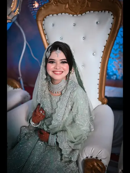 The bride's joyful, beaming smile captured as she sits on the grand reception stage. This photo is a perfect representation of her happiness on her wedding day.