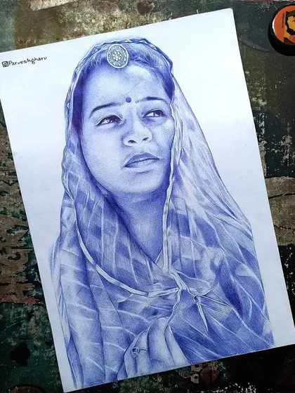 A finished portrait of the Rajasthani woman, created entirely with a blue ballpoint pen. The final piece highlights the traditional coin ornament on her forehead and the soft folds of her odhani.