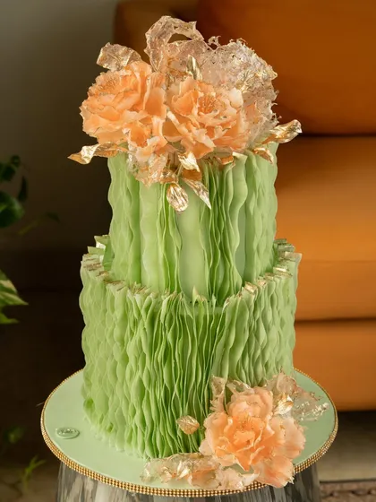 This cake demonstrates the versatility of the ruffle paper technique with its vibrant green color. The look is completed with beautiful, translucent sugar peonies in a contrasting peach shade, touched with gold leaf.