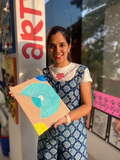 A participant with her finished abstract texture painting. The combination of colors and patterns creates a unique and modern piece.