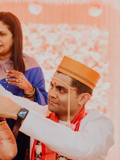The groom, Siddharth, places the mangalsutra on his bride, Karishma, a significant and beautiful moment in a Maharashtrian wedding.